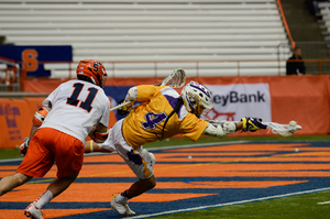 Lyle Thompson extends his arms for a ball behind the net, and finished the game with one goal and five assists. 