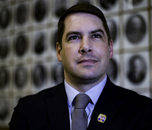 Mayor Ben Walsh stands in front of a wall with photos of past mayors of Syracuse. His grandfather's photo is on that wall. 