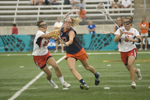 Syracuse senior midfielder Christina Dove cradles the ball as Maryland defender Karissa Taylor attempts to check the ball out of Dove's possesion in SU's 14-5 loss to the Terrapins Friday. For Dove, Friday's final four loss was the final game for the midfielder in a career in which she recorded an Orange-record 250 goals.  