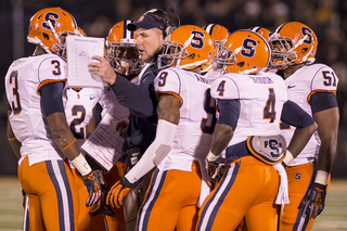 Members of the Syracuse defense huddle with head coach Doug Marrone.