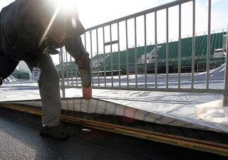 The court is seen as the technical director, Ken Freeman, lifts the tarp aboard the USS Midway Museum on Nov. 8, 2012 before the Battle on the Midway game between the Syracuse Orange and the San Diego State Aztecs scheduled for Sunday.