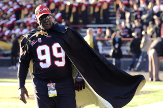 A fan storms the sideline with an extravagant cape. 