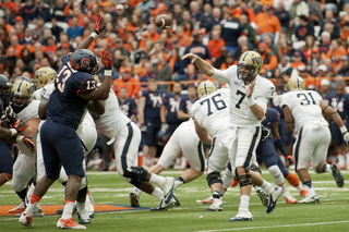 Pitt quarterback Tom Savage lofts a pass over defensive end Ron Thompson and the SU line.