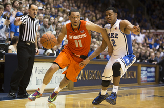 Tyler Ennis drives by Quinn Cook.