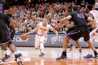 Guard Trevor Cooney dribbles the ball at the left corner of the paint.