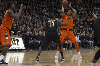 Michael Gbinije lifts the ball over his head as Pittsburgh's Josh Newkirk sticks a hand toward his face.