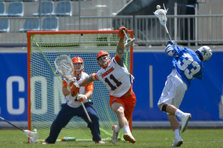 Duke's Justin Guterding fires a shot as SU defender Brandon Mullins contests and goalie Bobby Wardwell awaits.