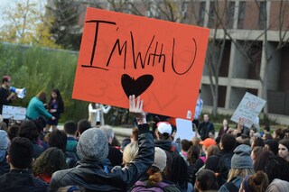 A student holds a sign that reads 