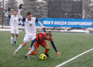 Syracuse defender Sondre Norheim is knocked to the ground going for a loose ball.