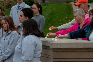 Remembrance Scholars Mira Berenbaum, Louis Smith and Jaime Heath stand in silence as attendees place electric candles at the Place of Remembrance. All three of the scholars signed a statement committing the cohort to shifting the mission of Remembrance to education and advocacy regarding antisemitism, Islamophobia and racism.